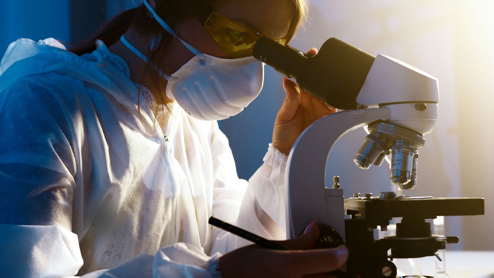 Scientist working at a microscope in a life-sciences lab